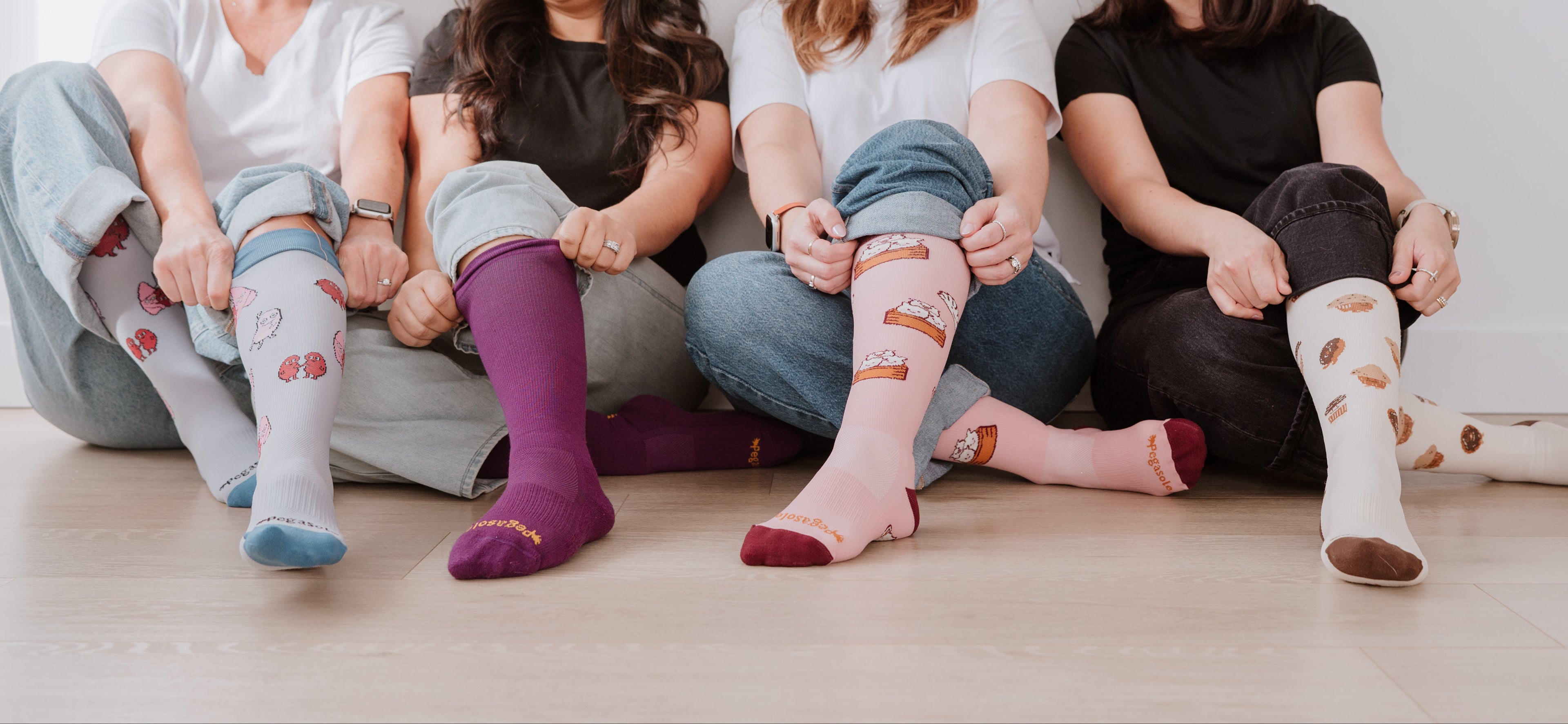 Four women sitting on the floor wearing Pegasole Compression socks.