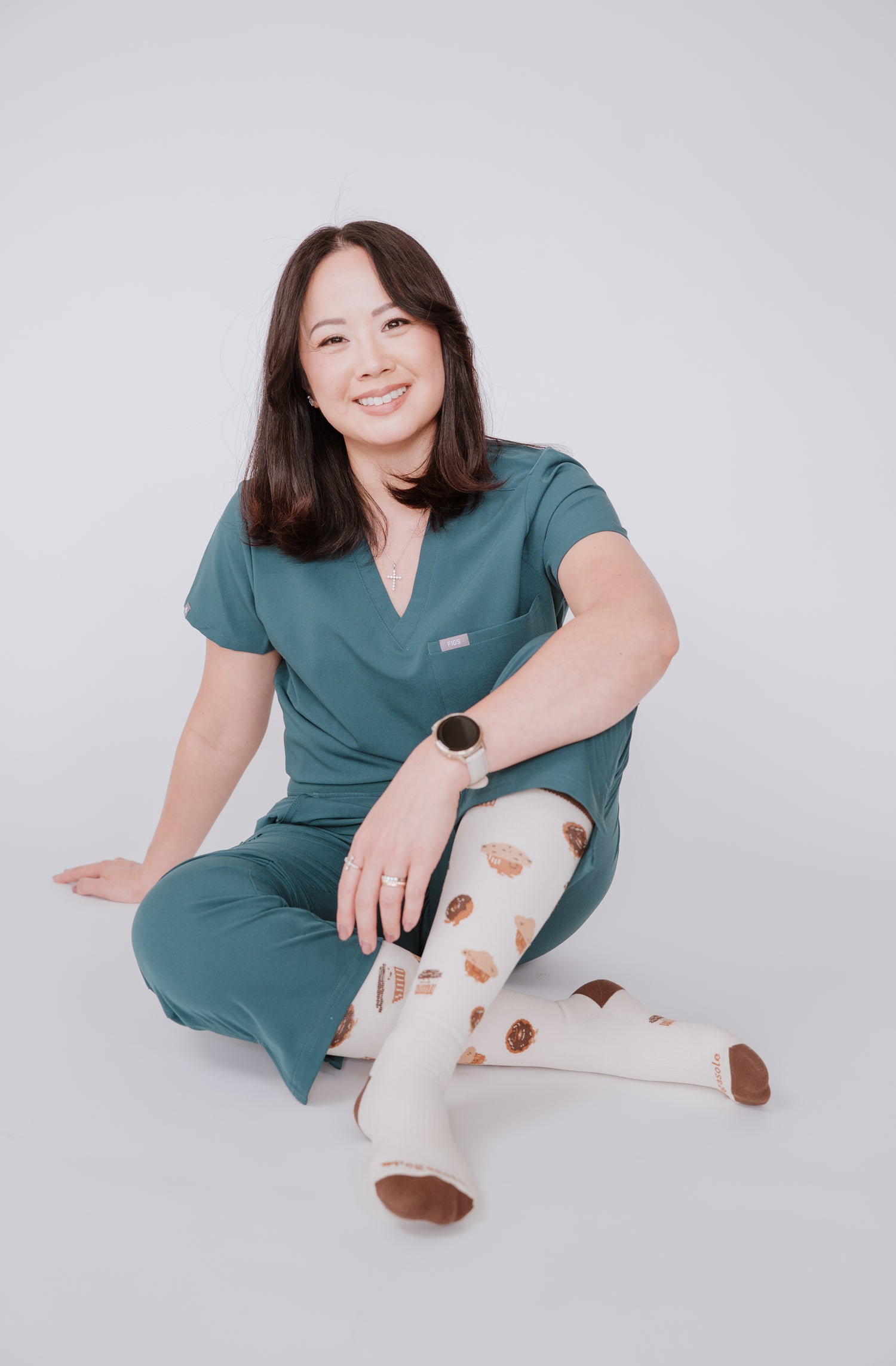 Tina, Owner of Pegasole in teal scrubs sitting on a white background